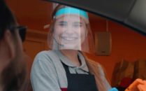 young woman at drive thru with face shield on
