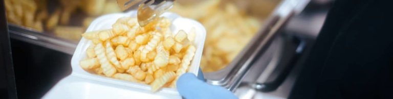 Professional Cook Putting French Fries in a Plastic Food Container